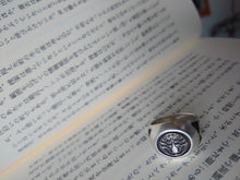 画像をギャラリービューアに読み込む, a sterling silver japanese kamon ring on top of a japanese novel
