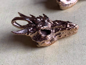 kings of alchemy  dragon skull pendant bronze no chain on table