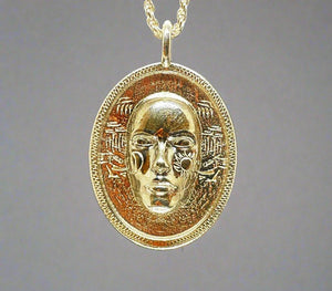 golden round face pendant with runes